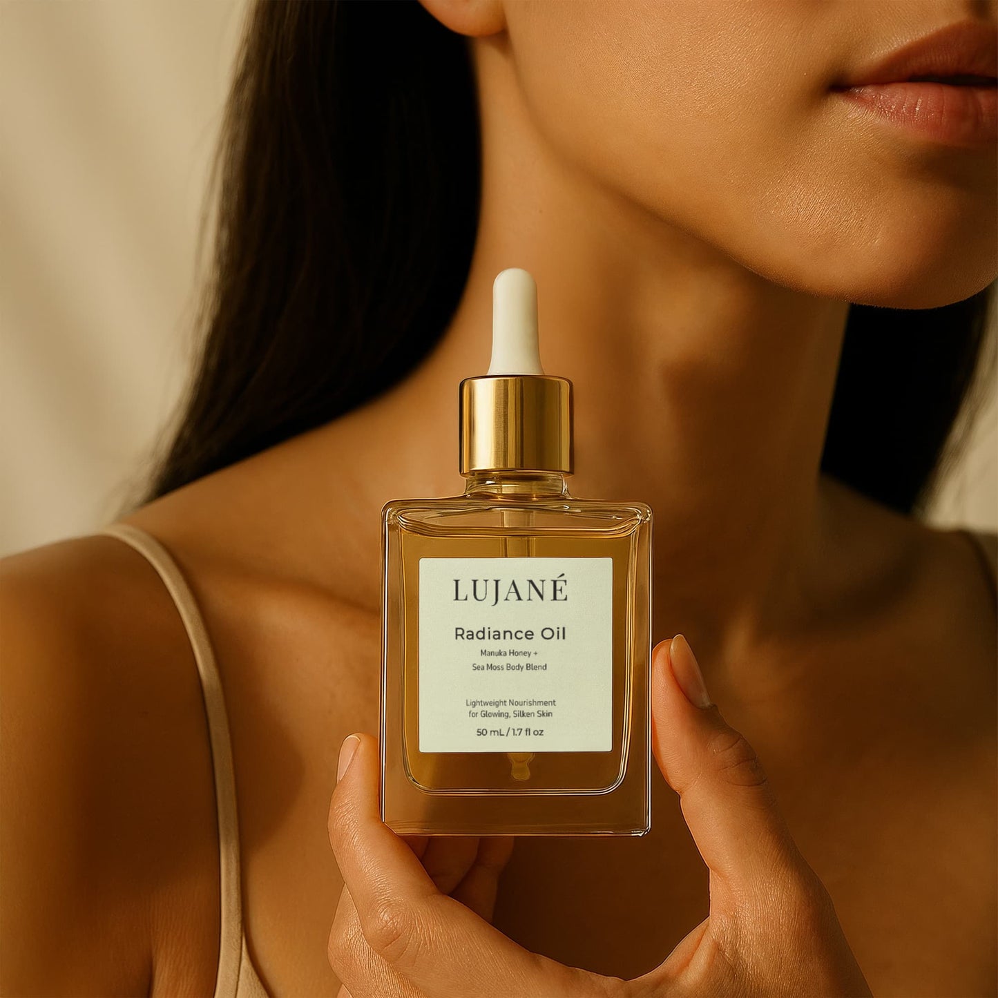 LUJANÉ Radiance Oil held in a luxury lifestyle setting; a potent Manuka Honey and Sea Moss body blend designed to provide lightweight nourishment for glowing, silken skin.