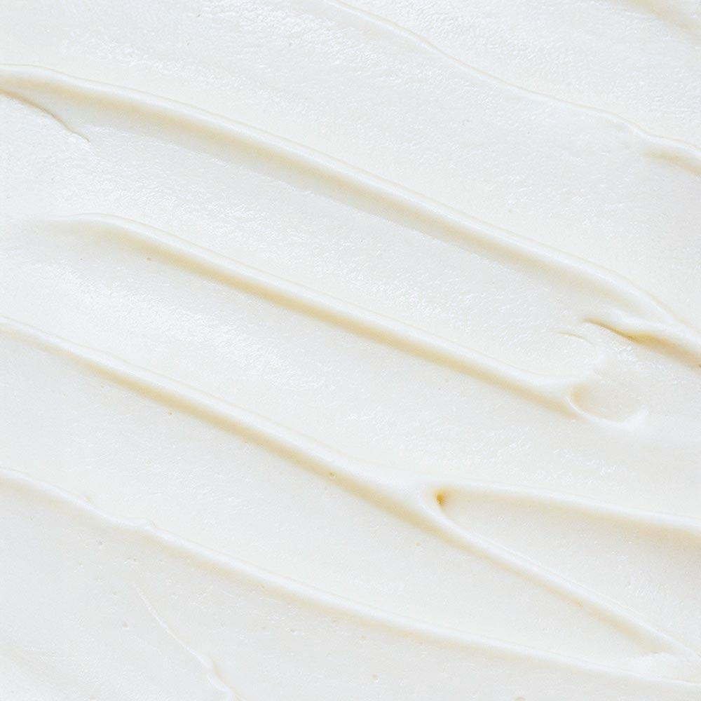 A macro close-up showing the rich, creamy, and whipped texture of LUJANÉ Renewal Balm, highlighting the smooth consistency of grass-fed tallow for deep skin nourishment.